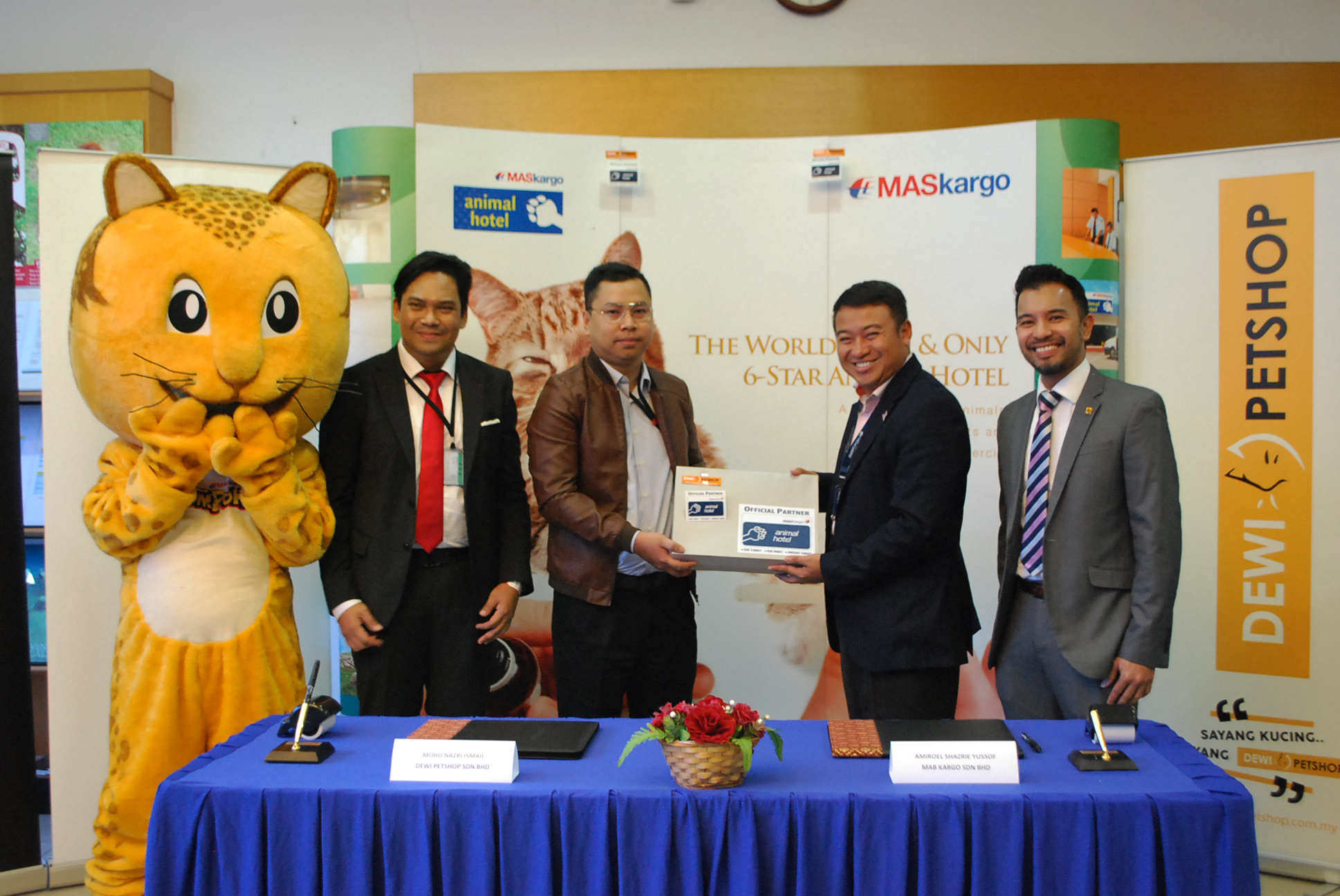 Handing of Promotional Pack by MAB Kargo Sdn Bhd CEO, Ahmad Luqman Mohd Azmi (right) to Dewi Pet Shop Sdn Bhd Executive Director, Mohd Fairos Abdul Rasid (left).